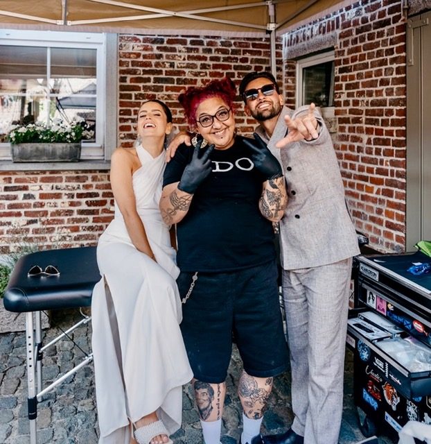 Mariska met een bruidspaar bij haar tattoo-opstelling op hun trouwlocatie.