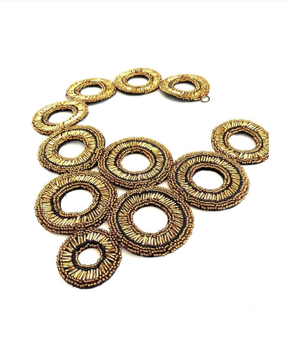 Ketting van goudkleurige, met kralen bewerkte ringen.