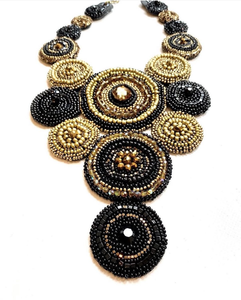Statement-ketting in goud en zwart met ronde kraalmedaillons.