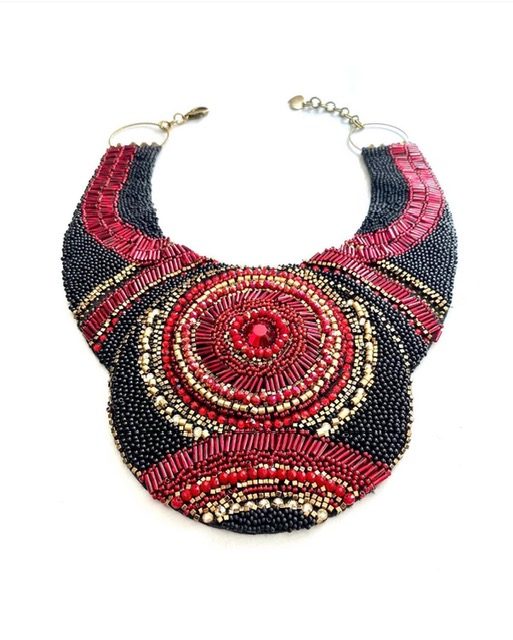 Statement-ketting in rood, zwart en goud met kralen, op wit.