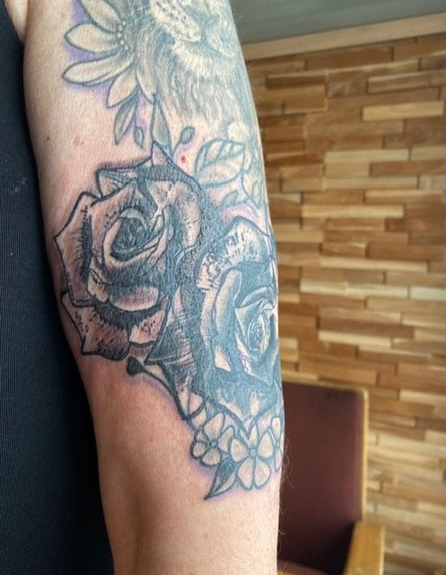 Rozen die een oudere tattoo bedekken — voorbeeld van een cover-up.