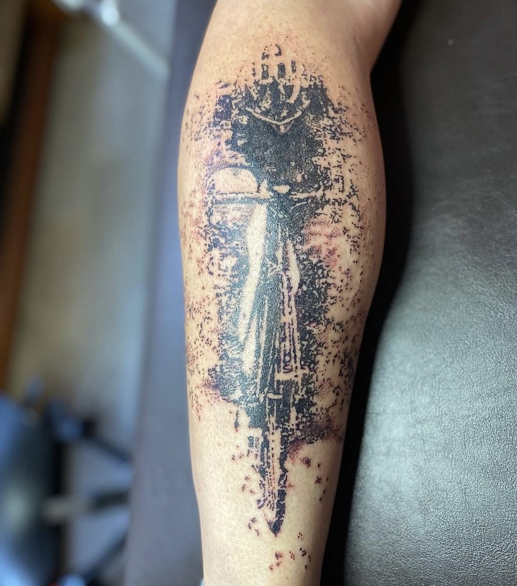 Straatlantaarn met wegvliegende vogels, dotwork op de kuit.