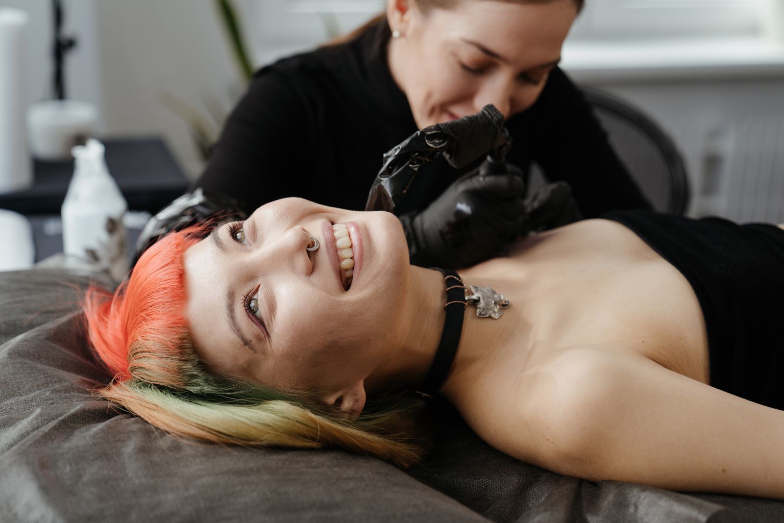 Sfeerbeeld ter illustratie (stockfoto): een tatoeëerder aan het werk in een lichte studio — dit is geen foto van CirK Tattoo.