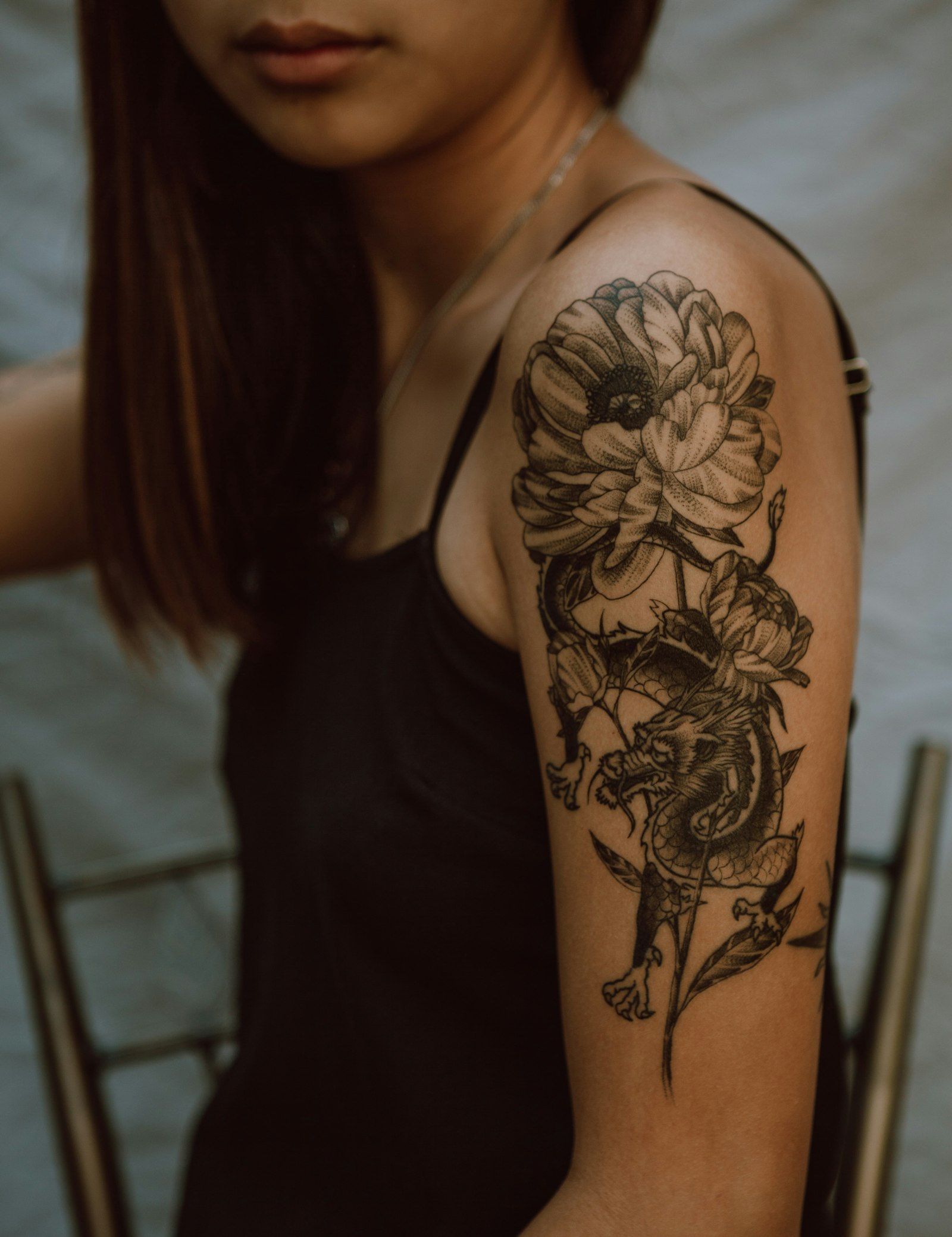 Stockfoto ter illustratie van de florale stijl: een schouder met een bloementattoo in zwart-grijs — geen werk van CirK Tattoo.